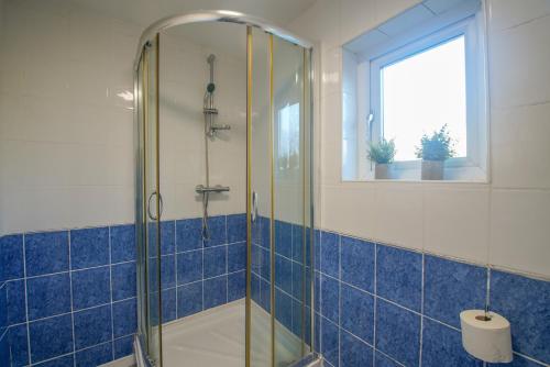 a bathroom with a shower with blue tiles at Comfy House for Contractors, Families, Accrington in Accrington