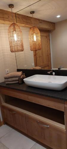 La salle de bains est pourvue d'une grande baignoire et de deux lumières. dans l'établissement Chez Francis Appart entre lacs et montagnes, à Les Villards-sur-Thônes