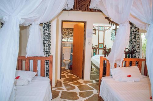 Tempat tidur dalam kamar di Kijani Cottages In Diani