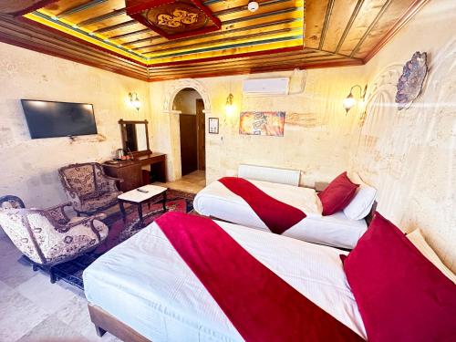 a hotel room with two beds and a television at Balloon Cave Hotel in Goreme