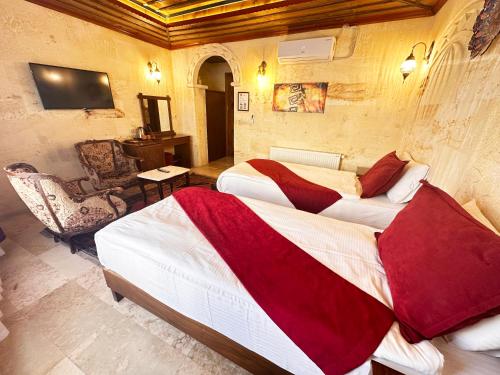 a hotel room with two beds and a chair at Balloon Cave Hotel in Göreme