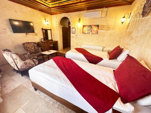 a hotel room with two beds and a chair at Balloon Cave Hotel in Goreme