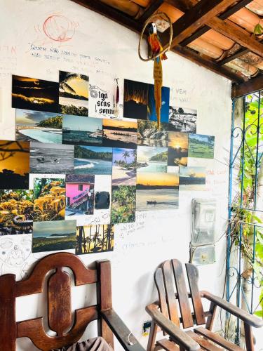 two chairs against a wall with pictures on it at adriana hostel in Itacaré