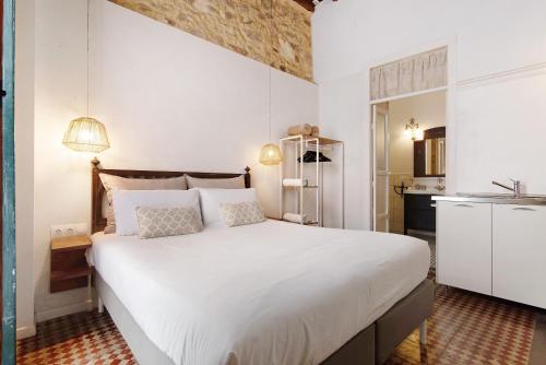 um quarto com uma grande cama branca e uma cozinha em Apto López - Casa San Marcial em Las Palmas de Gran Canaria