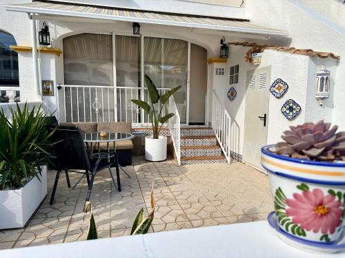 a patio with a table and chairs and a house at Sonido del Mar in Gran Alacant