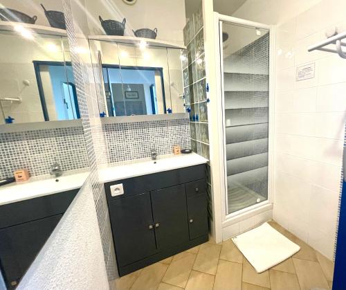 une salle de bain avec deux lavabos et une douche dans l'établissement PGH N26 - Première Ligne, Jardin et Parking Privé, à La Grande Motte