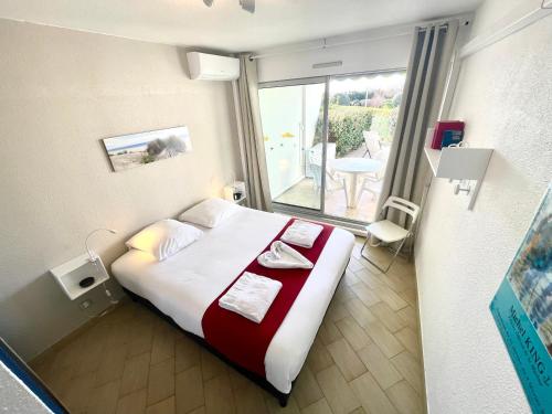 une chambre d'hôtel avec un lit et une grande fenêtre dans l'établissement PGH N26 - Première Ligne, Jardin et Parking Privé, à La Grande Motte