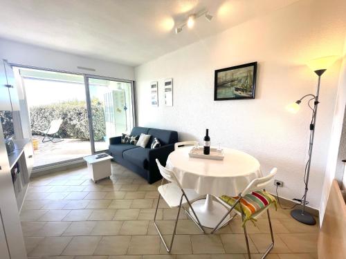 un salon avec une table et un canapé dans l'établissement PGH N26 - Première Ligne, Jardin et Parking Privé, à La Grande Motte