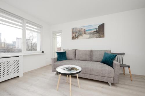 een woonkamer met een bank en een tafel bij Elegant Apartment in the centre of Gdynia by Renters in Gdynia