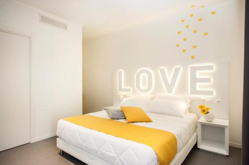 a bedroom with a bed with a love sign on the wall at Love Boat Hotel - The Original in Riccione