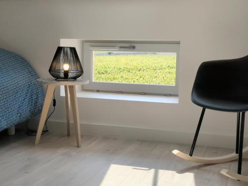 a bedroom with a window and a table with a lamp at La Maison de Caro in Gevrey-Chambertin