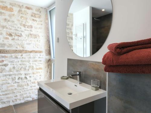 La salle de bains est pourvue d'un lavabo blanc et d'un miroir. dans l'établissement La Maison de Caro, à Gevrey-Chambertin