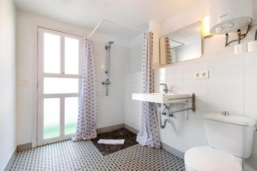 a bathroom with a sink and a toilet and a window at Apto Tatiana - Casa San Marcial in Las Palmas de Gran Canaria