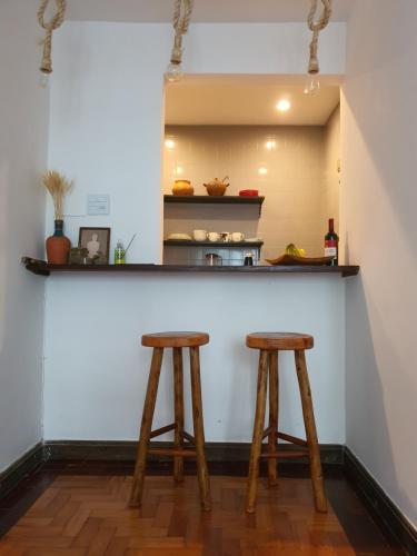 una encimera con 2 taburetes de madera en una cocina en Apartamento 4 quartos 500m Arpoador, en Río de Janeiro