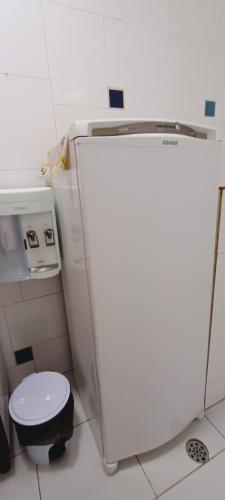 a white refrigerator in a kitchen with a toilet at Hóspede do Lar Amoroso Bed & Breakfast in Salvador