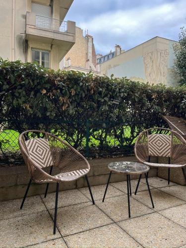deux chaises et une table devant une haie dans l'établissement Paris Tour Eiffel, à Paris