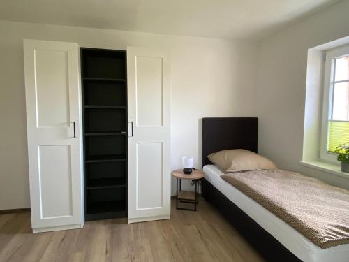 a bedroom with a bed and a table and a window at Haus Mariechen Whg 2 in der Nähe zum Silbersee mit gemütlicher Terrasse & Sauna in Frielendorf