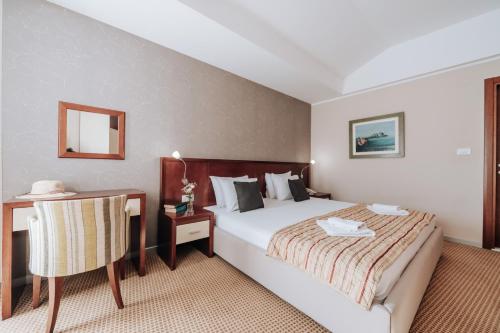 - une chambre avec un lit, une table et une chaise dans l'établissement Apartments Del Mar, à Petrovac na Moru