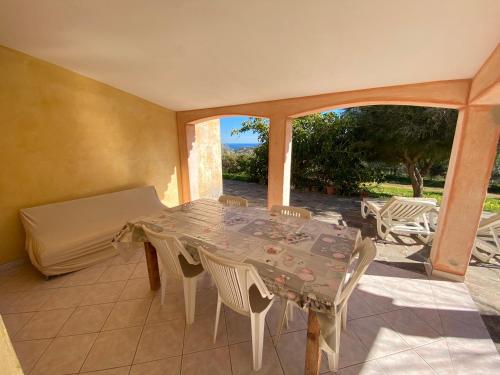 a patio with a table and chairs and a bed at Villa Verde in Tertenìa