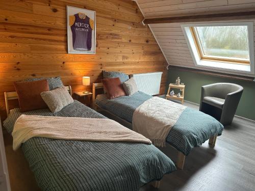 1 dormitorio con 2 camas en una cabaña de madera en 't Coureurke, en Brakel