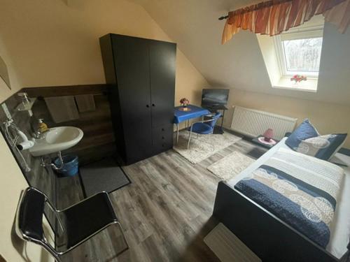 a bedroom with a bed and a sink and a bathroom at Pension Krahmer in Chemnitz