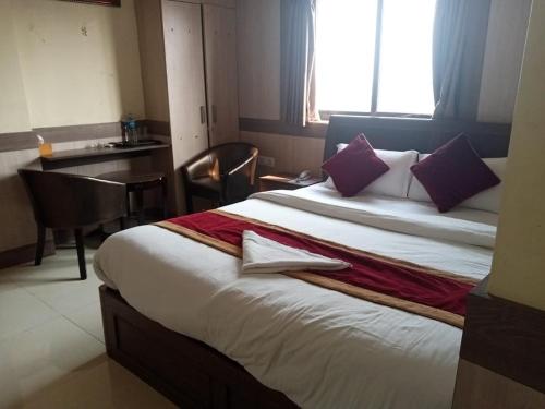 a hotel room with a large bed with purple pillows at Hotel C O International in Kathmandu