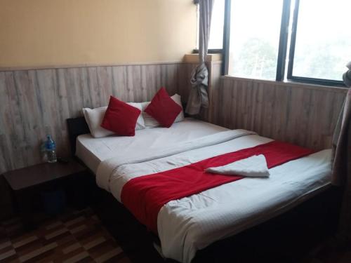 a large bed with red and white sheets and pillows at Hotel C O International in Kathmandu