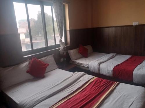 two beds sitting in a room with a window at Hotel C O International in Kathmandu