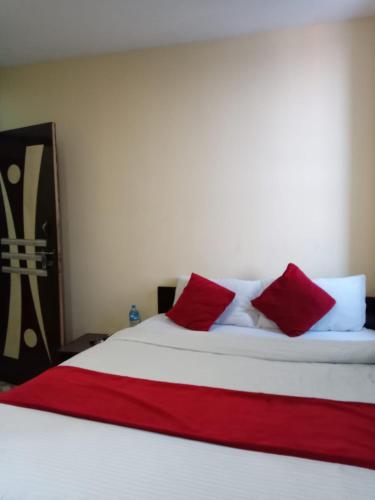 a bed with red and white pillows on it at Hotel C O International in Kathmandu