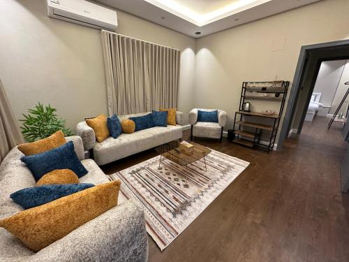 a living room with two couches and a table at Riyadh Cozy Stylish One-Bedroom Apartment in Riyadh