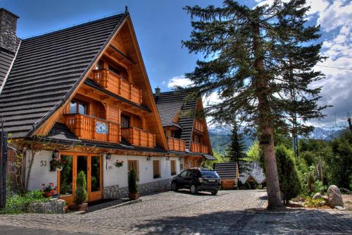 a house with a car parked in front of it at Willa Pod Orłem Jacuzzi Sauna in Kościelisko