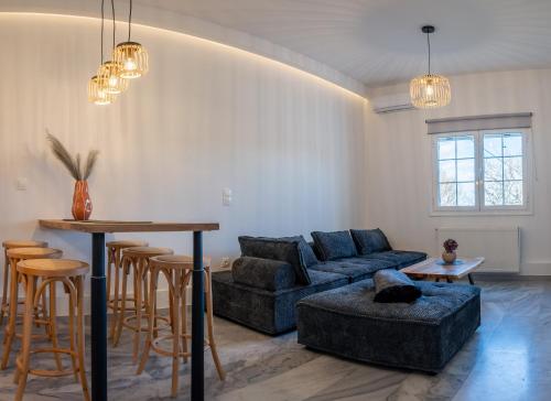 - un salon avec un canapé bleu et une table dans l'établissement Noho Villas @ Sunlit house Paros, à Nea Cryssi Akti