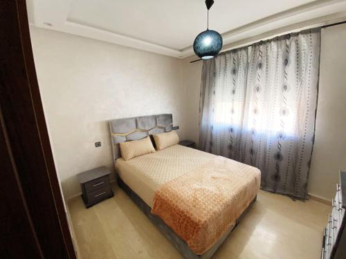 a bedroom with a bed and a window at Elégant studio proche de toutes commodités dans le quartier des Roches Noires in Casablanca