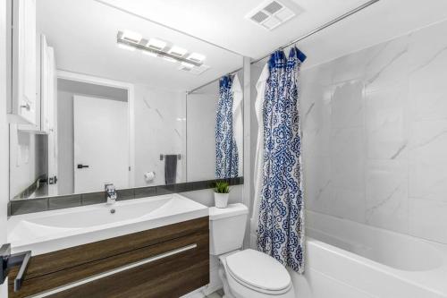 W łazience znajduje się umywalka, toaleta i lustro. w obiekcie 2 BR Waterfront Condo Downtown w/ free Parking w mieście Toronto