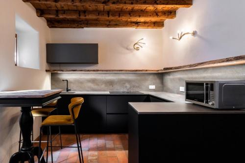 eine Küche mit einer Mikrowelle und einer Theke mit Stühlen in der Unterkunft Relais Villa Carrara in Villa di Serio