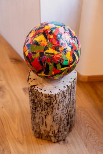 a colorful glass ball sitting on top of a tree stump at Relais Villa Carrara in Villa di Serio
