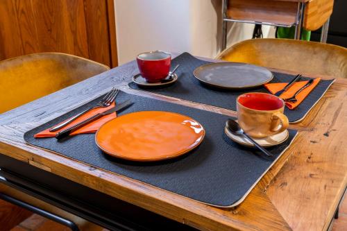 a table with two plates and two cups and utensils at Relais Villa Carrara in Villa di Serio