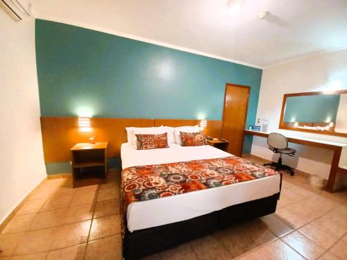a hotel room with a bed and a desk at Hotel Riviera in Araçatuba