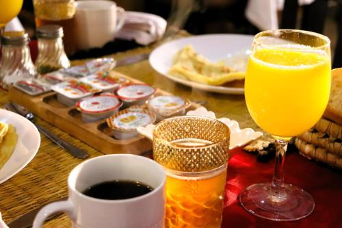 a table with a glass of orange juice and a cup of coffee at Riad ait Ben Haddou in Aït Ben Haddou