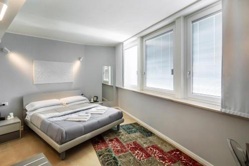 a bedroom with a bed and two windows at Golgi Suite in Pavia
