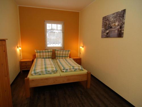 um quarto com uma cama com duas almofadas e uma janela em 2-room apartment in Lübben in the Spreewald em Lübben