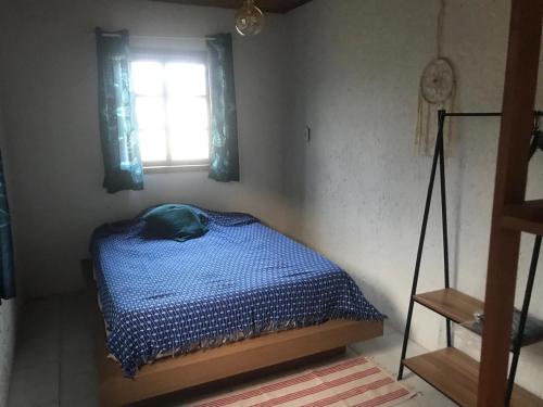 a bedroom with a bed in a room with a window at Casa Jasmim in Imbituba