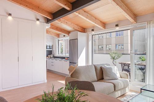 ein Wohnzimmer mit einem Sofa und einer Küche in der Unterkunft Santa Lucía in A Coruña