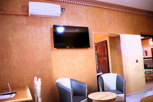 a waiting room with chairs and a tv on a wall at Riad ait Ben Haddou in Aït Ben Haddou