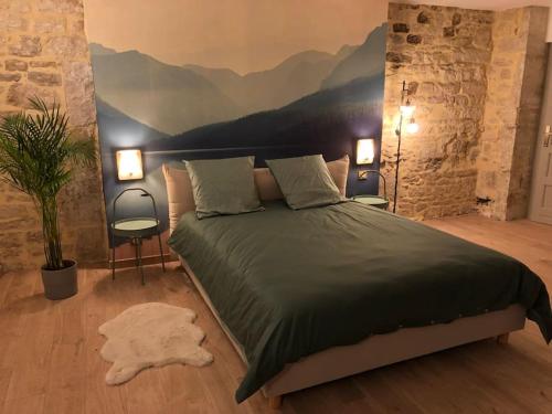 ein Schlafzimmer mit einem Bett mit einem Wandbild der Berge in der Unterkunft Nuits centre : superbe gîte rénové et climatisé in Nuits-Saint-Georges