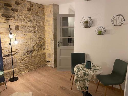 une pièce avec une table et des chaises et un mur de briques dans l'établissement Nuits centre : superbe gîte rénové et climatisé, à Nuits-Saint-Georges