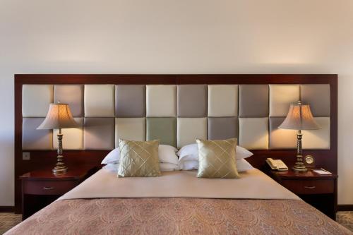 a bedroom with a large bed with two lamps at Grand Hotel Excelsior in Valletta