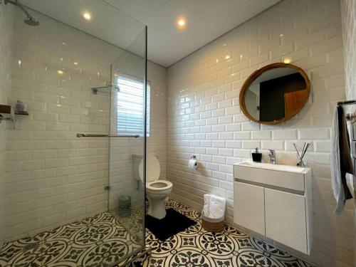 uma casa de banho com um WC, um lavatório e um espelho. em Cosy Comfort Guest Suit em Durban