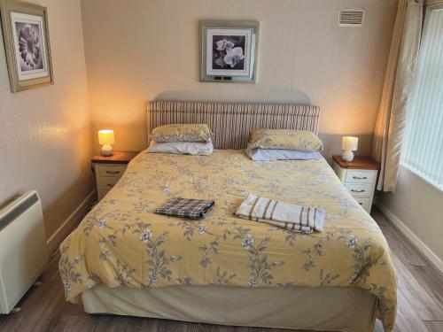 - une chambre avec un lit et une couette jaune dans l'établissement Feorline Cottage, à Lochgoilhead