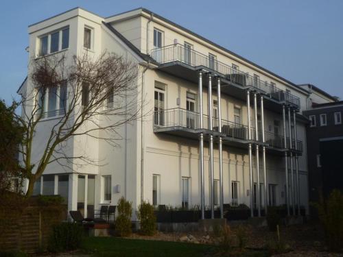 ein weißes Gebäude mit Balkon auf der Seite in der Unterkunft Rodehuus Wohnung 10 in Borkum